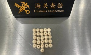 杭州萧山机场海关拦截查获象牙珠子26件，一旅客将其混装在坚果罐头中